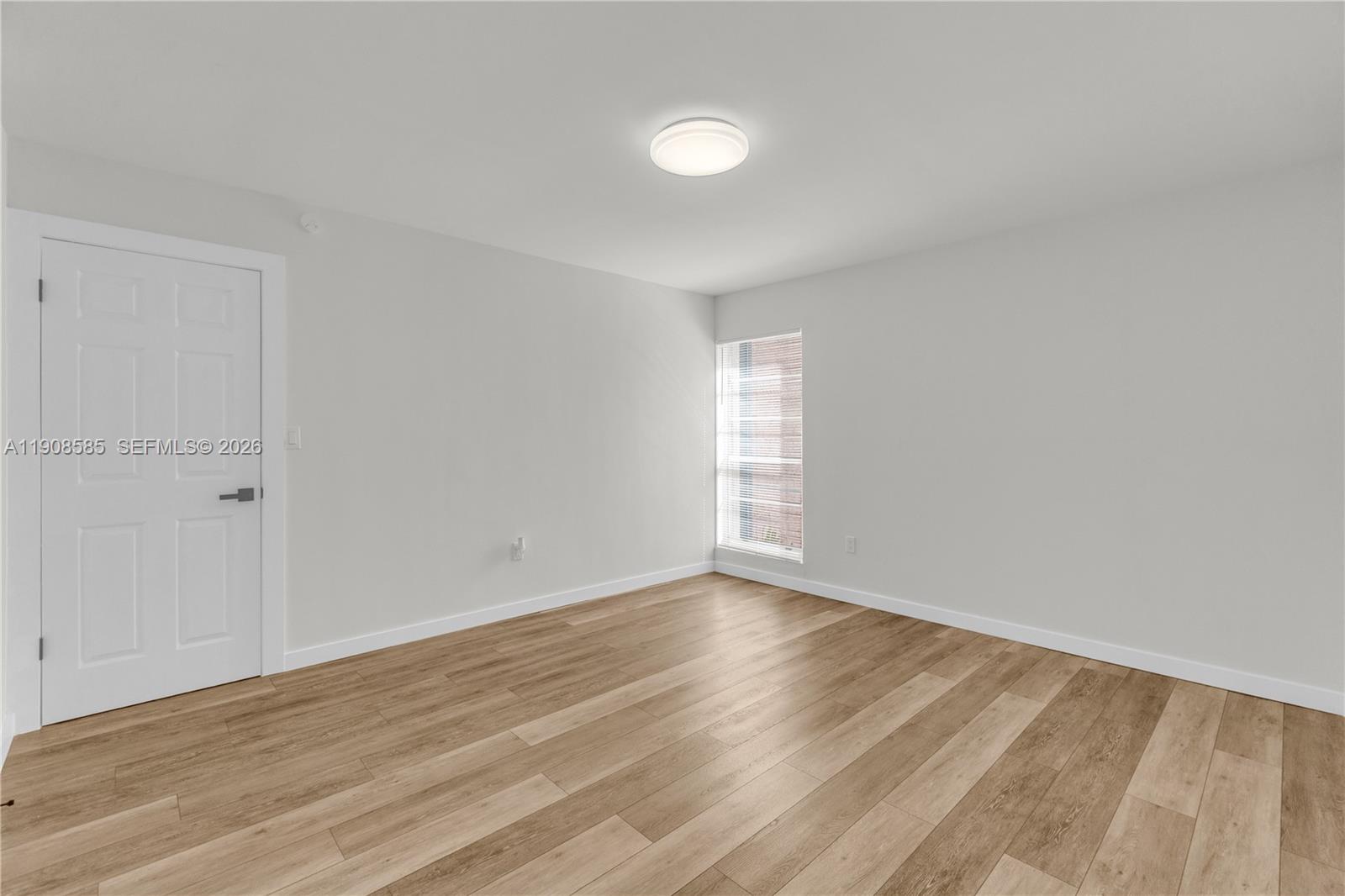 4709 Northwest 7th Street, Unit 2049 Miami, FL 33126 - Photo 3 of 51 a view of an empty room with wooden floor and a window