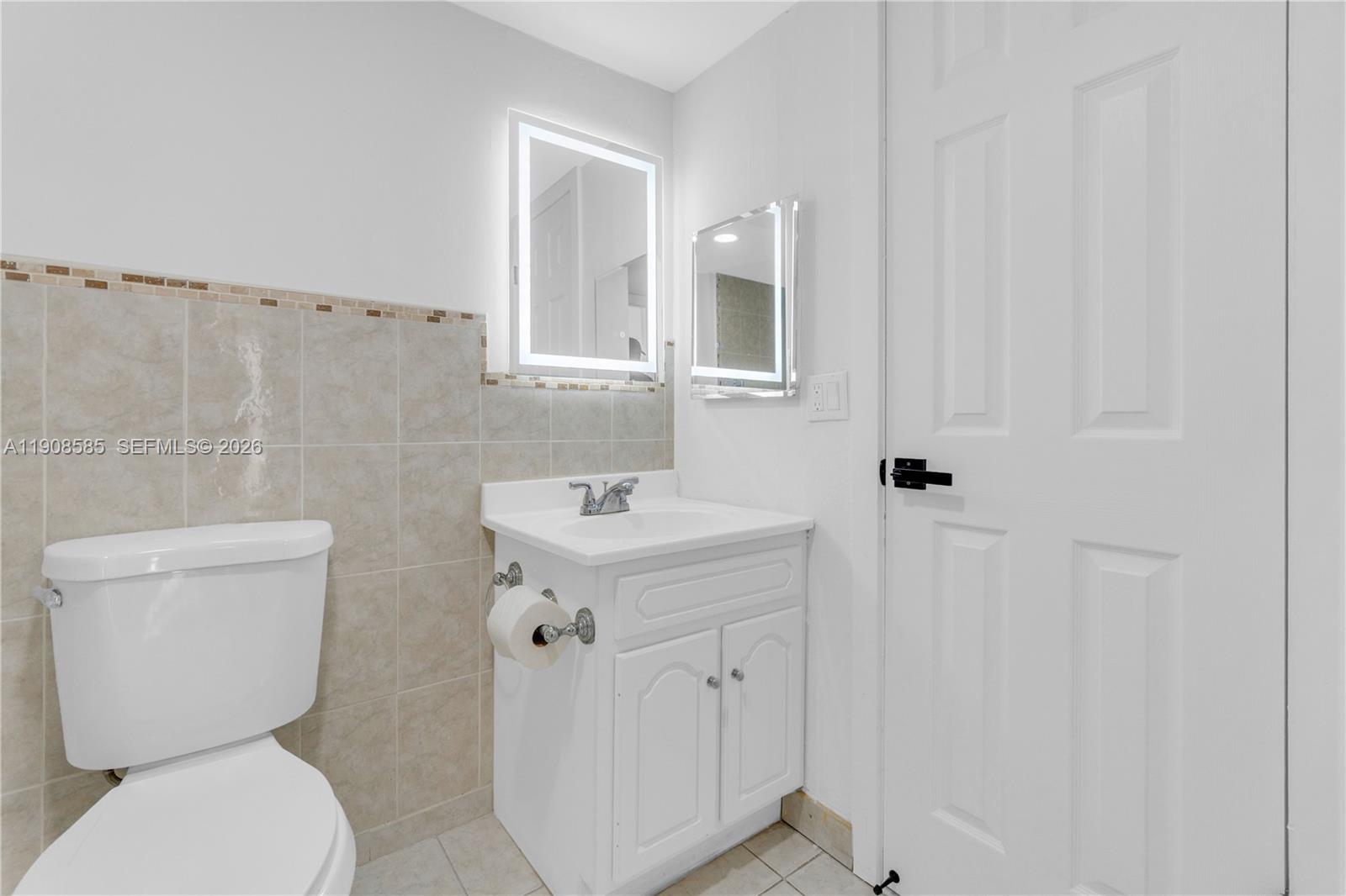 4709 Northwest 7th Street, Unit 2049 Miami, FL 33126 - Photo 38 of 51 a bathroom with a toilet sink and mirror