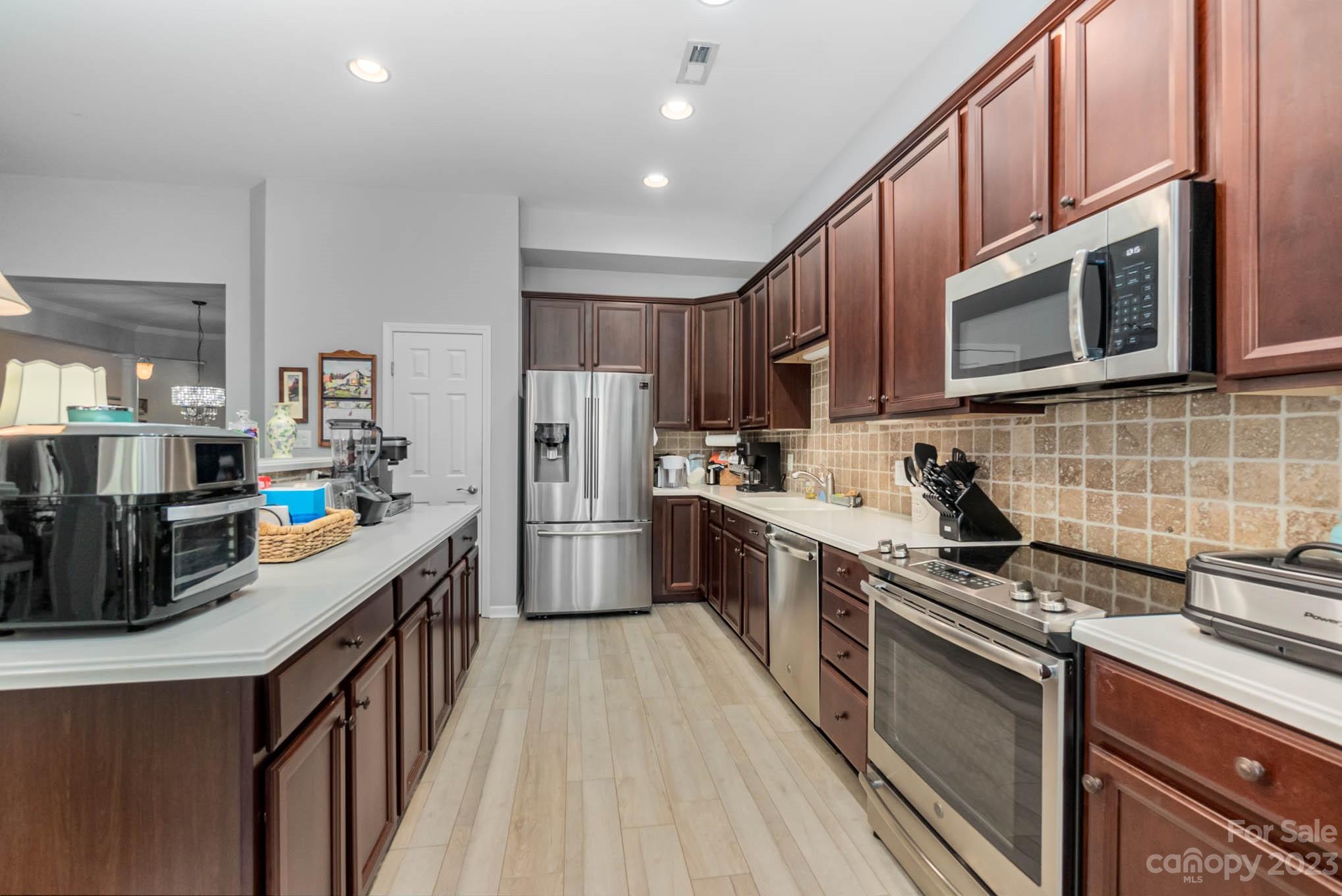 112 Pine Lake Drive Monroe, NC 28110 - Photo 12 of 37 a kitchen with refrigerator a microwave a stove and cabinets