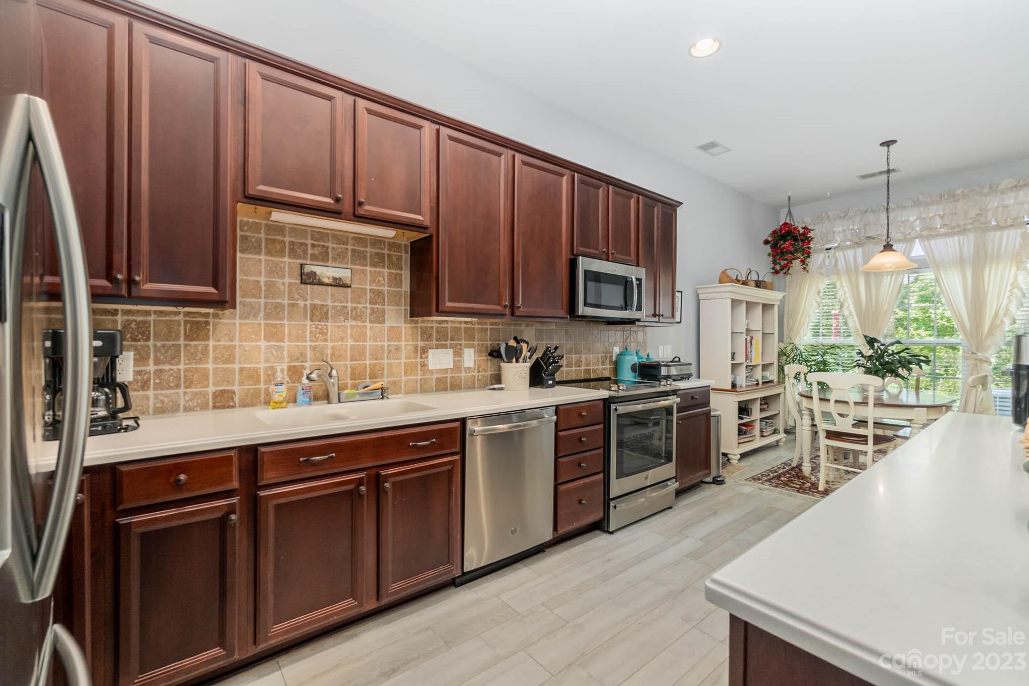 112 Pine Lake Drive Monroe, NC 28110 - Photo 13 of 37 a kitchen with stainless steel appliances wooden cabinets and a stove top oven