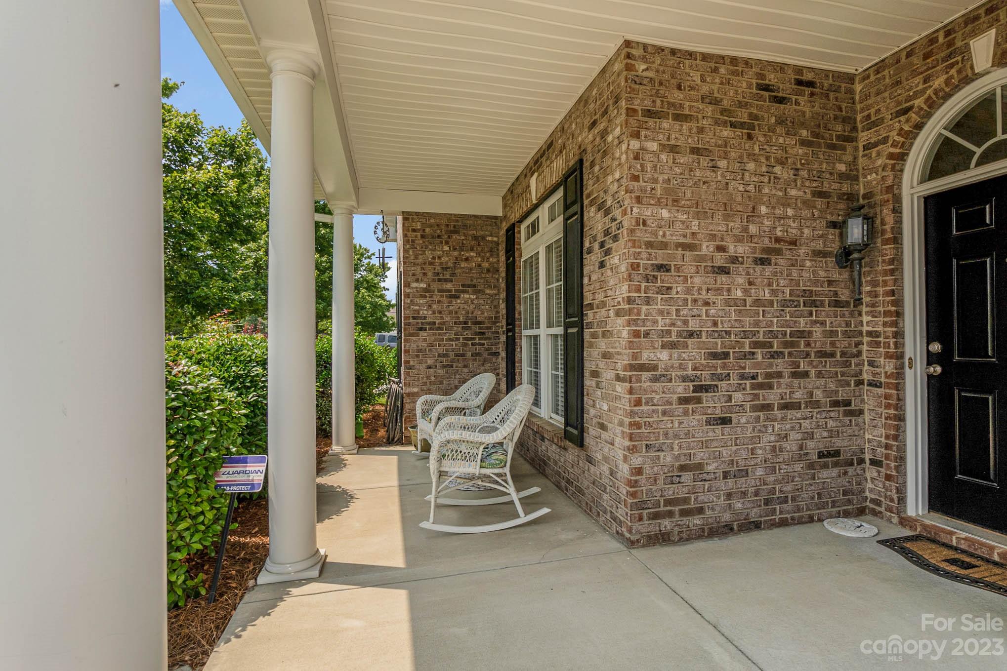 112 Pine Lake Drive Monroe, NC 28110 - Photo 6 of 37 a brick building with a canopy over it with table and chairs