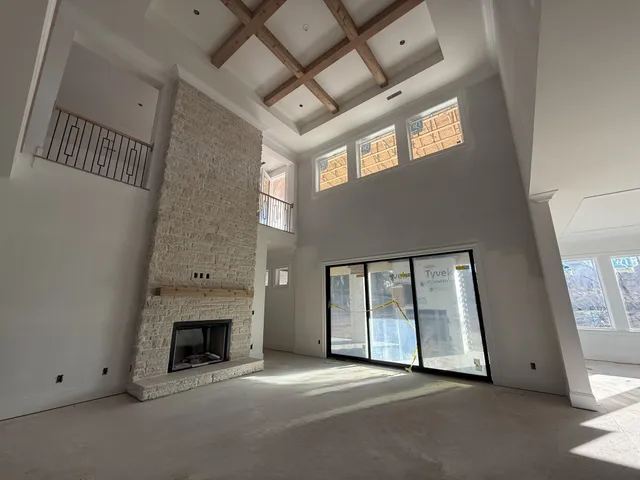 a view of an empty room with a fireplace and a window