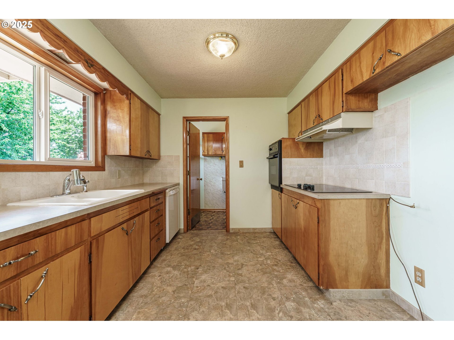 1938 Northwest Sierra Lane Camas, WA 98607 - Photo 9 of 33 a kitchen with granite countertop a sink cabinets stainless steel appliances and a large window
