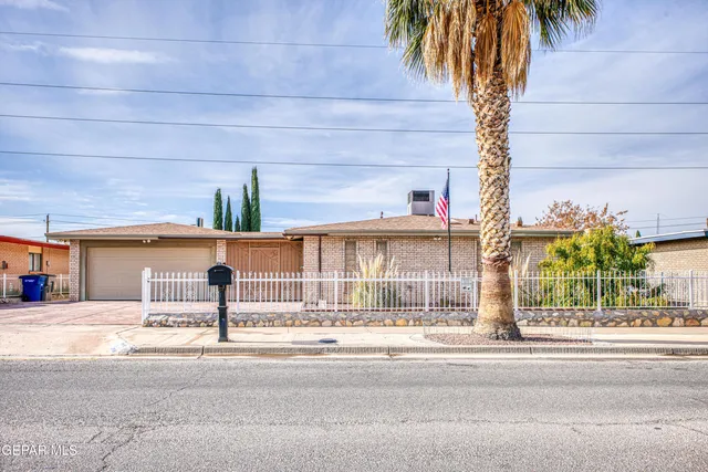 a view of a building with a yard and a palm trees