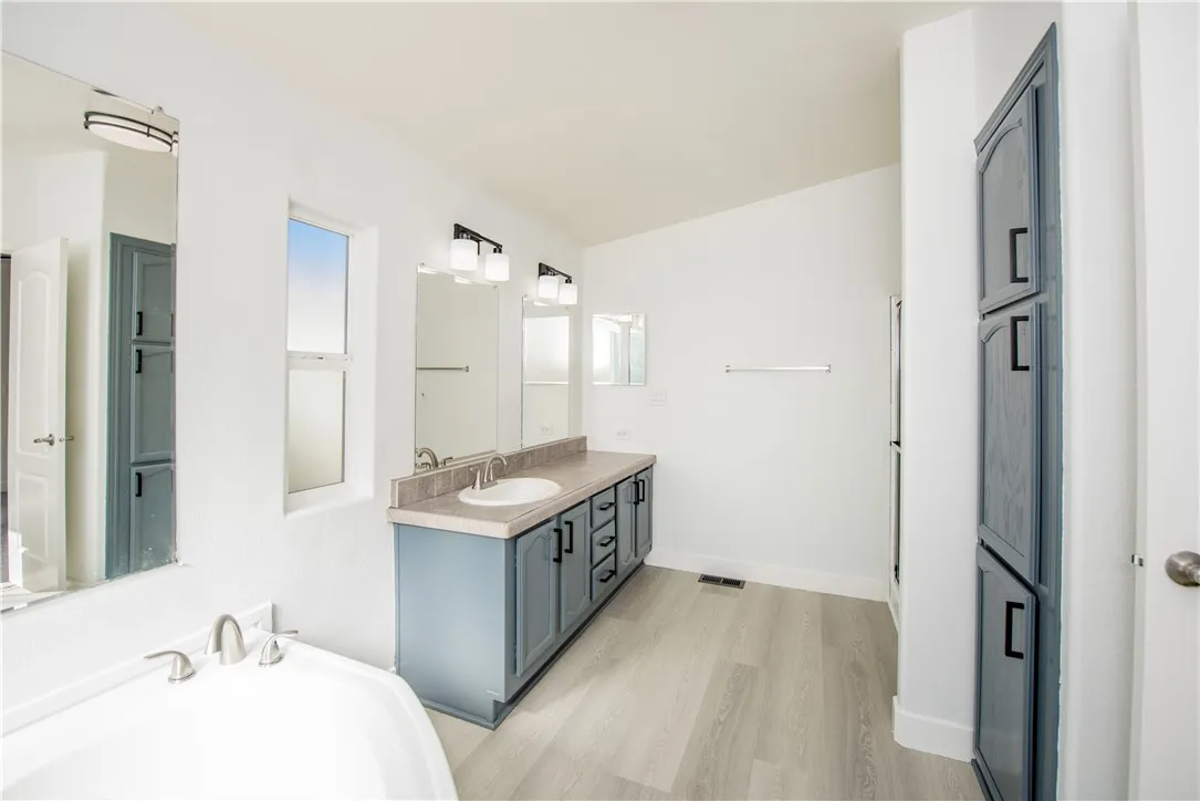 1051 Site, Unit 31 Brea, CA 92821 - Photo 24 of 35 a bathroom with a granite countertop double vanity sink a mirror and a shower
