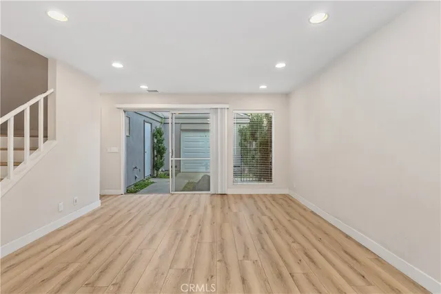 a view of a hallway with wooden floor and entryway