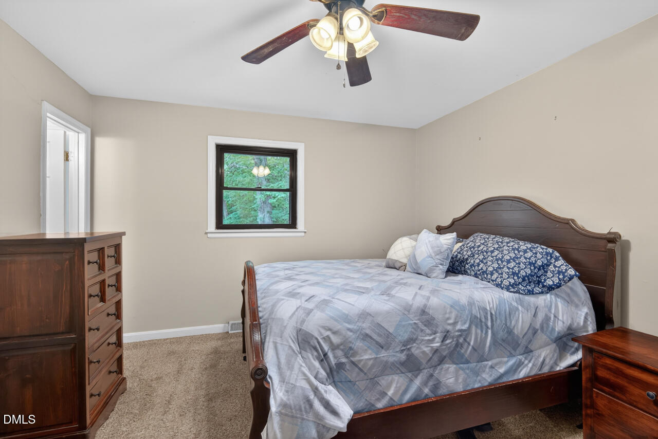 1420 Goodwin Road Durham, NC 27712 - Photo 25 of 54 a bedroom with a bed and a chandelier