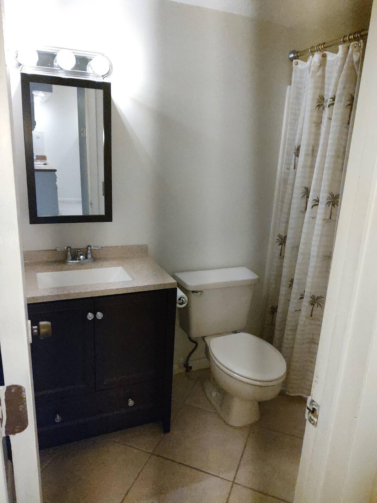 6341 Chasewood Drive, Unit B Jupiter, FL 33458 - Photo 14 of 14 a bathroom with a sink vanity and a toilet