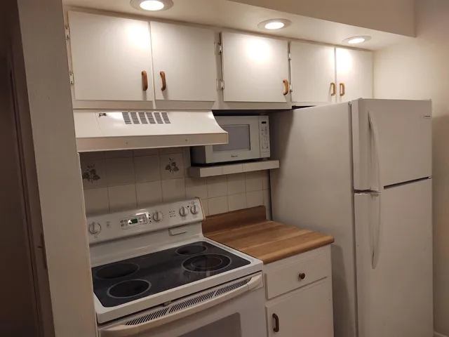 a kitchen with a stove cabinets and a refrigerator
