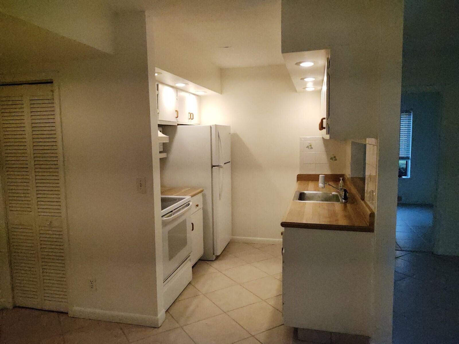 6341 Chasewood Drive, Unit B Jupiter, FL 33458 - Photo 5 of 14 a kitchen with stainless steel appliances granite countertop a refrigerator and a stove