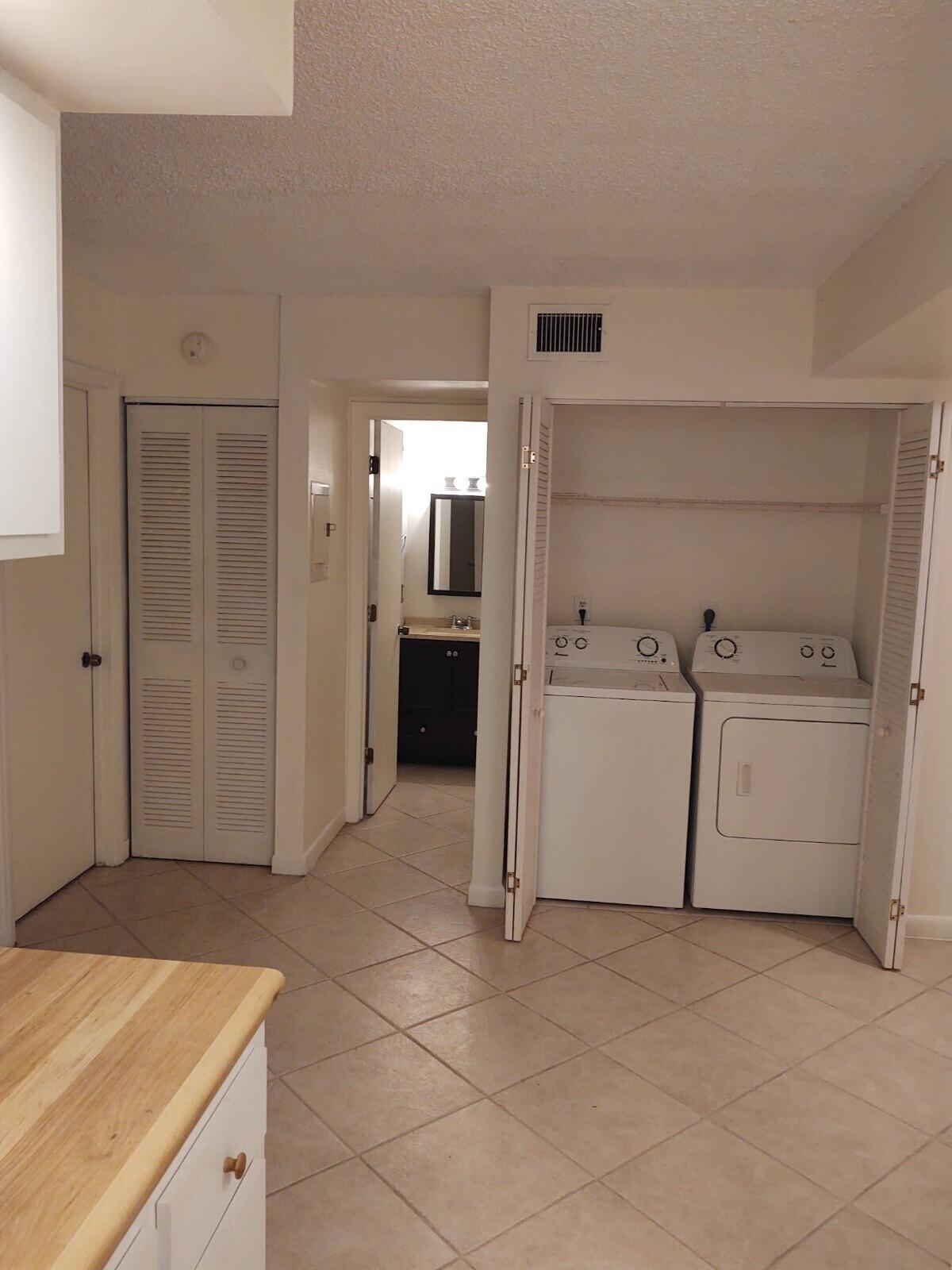 6341 Chasewood Drive, Unit B Jupiter, FL 33458 - Photo 7 of 14 a utility room with cabinets washer and dryer
