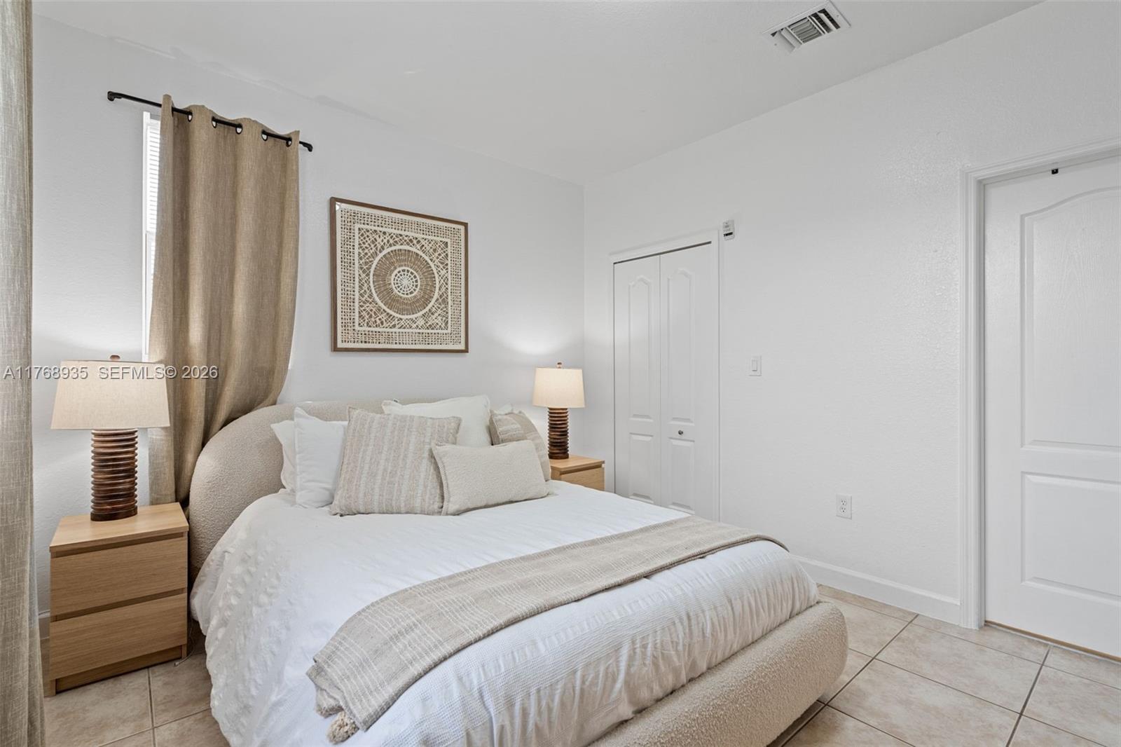 2731 Southeast 17th Avenue, Unit 211 Homestead, FL 33035 - Photo 14 of 26 a bedroom with a lamp and a bed