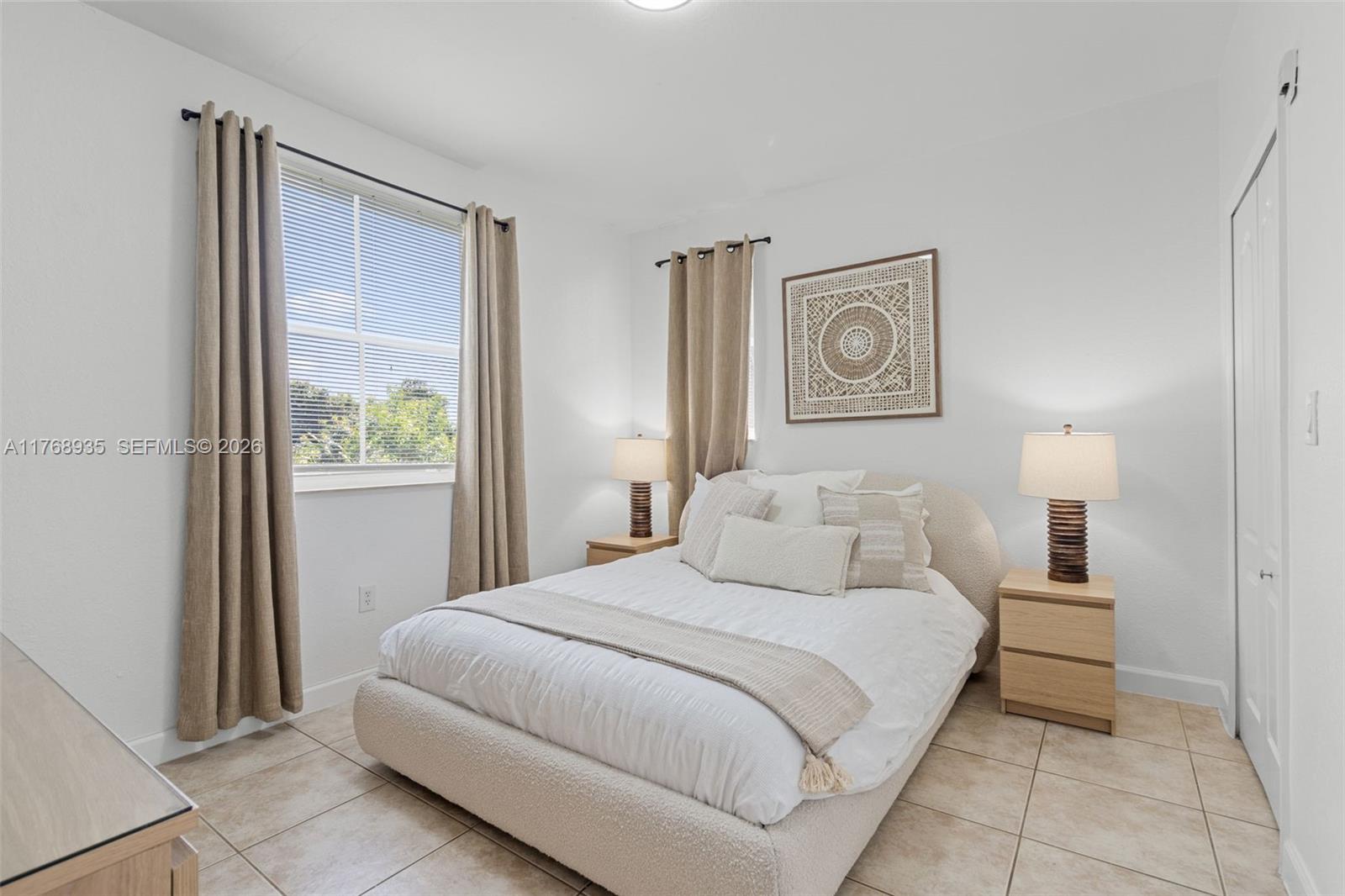 2731 Southeast 17th Avenue, Unit 211 Homestead, FL 33035 - Photo 15 of 26 a bedroom with a bed and a lamp