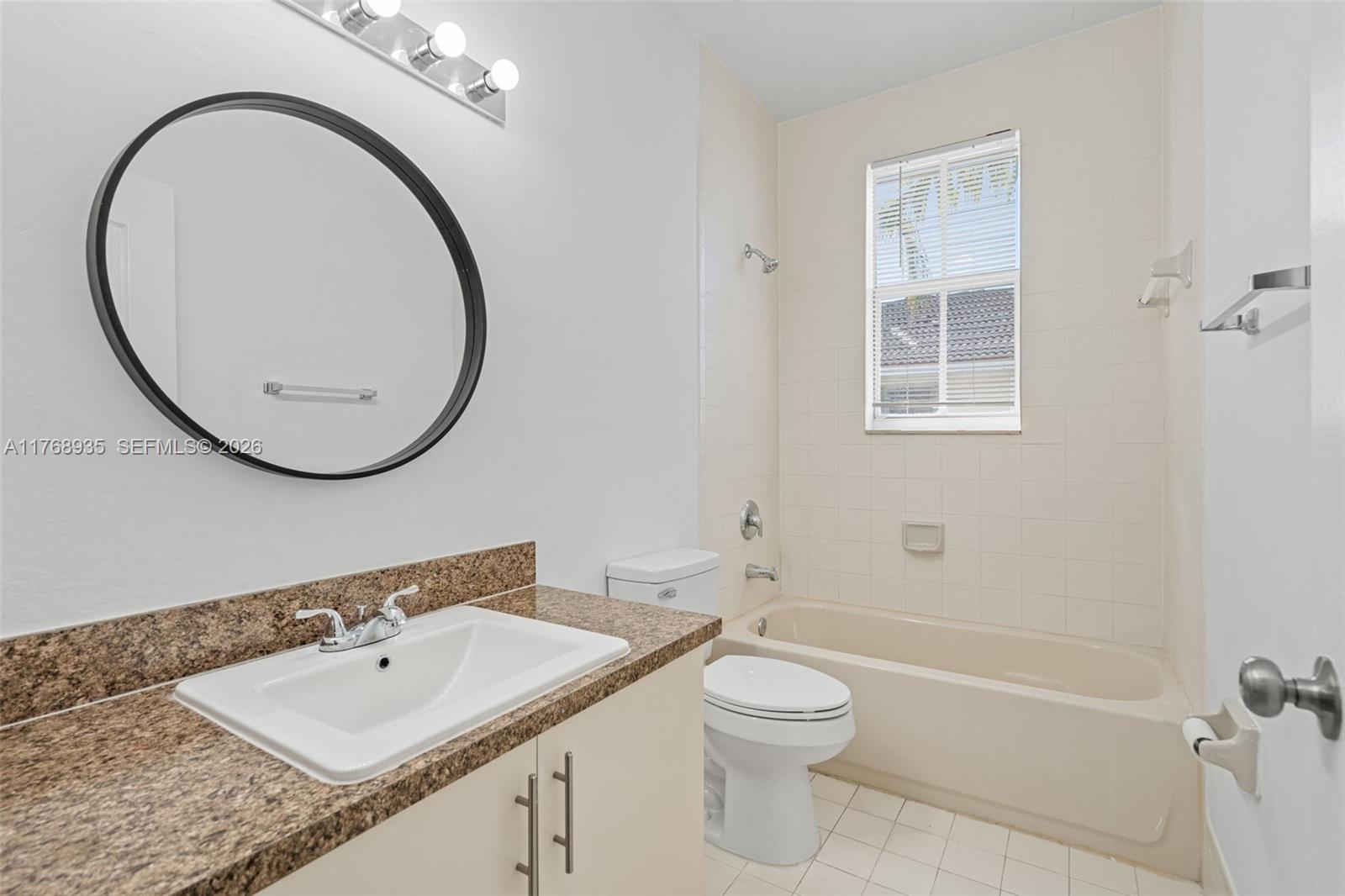 2731 Southeast 17th Avenue, Unit 211 Homestead, FL 33035 - Photo 22 of 26 a bathroom with a sink a toilet and a mirror