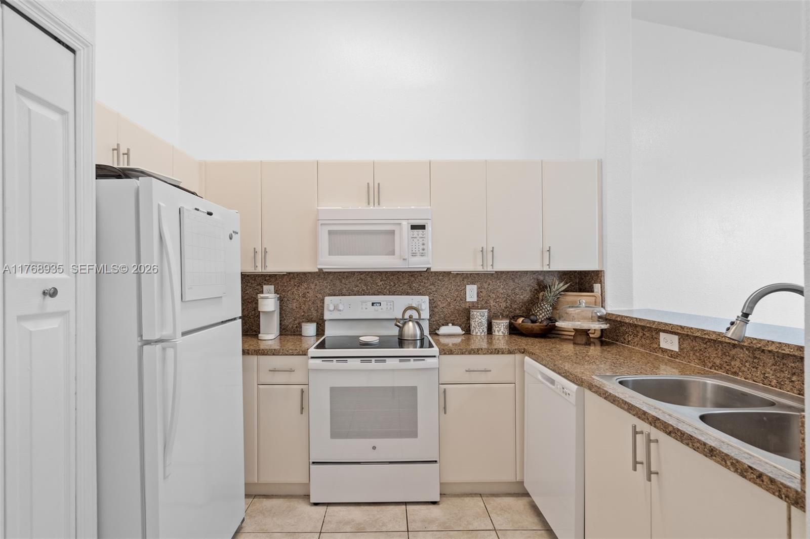 2731 Southeast 17th Avenue, Unit 211 Homestead, FL 33035 - Photo 9 of 26 a kitchen with a sink cabinets and refrigerator