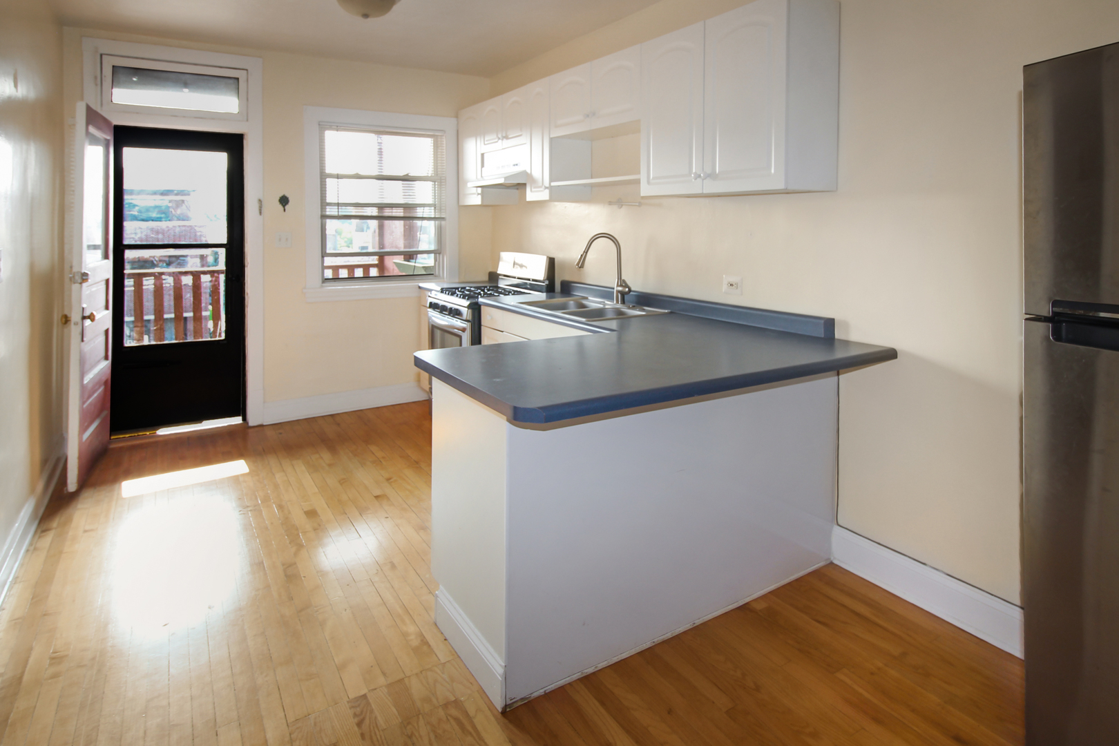 125 North Addison Avenue, Unit 3 Elmhurst, IL 60126 - Photo 8 of 16 a kitchen with a sink wooden floor and a window