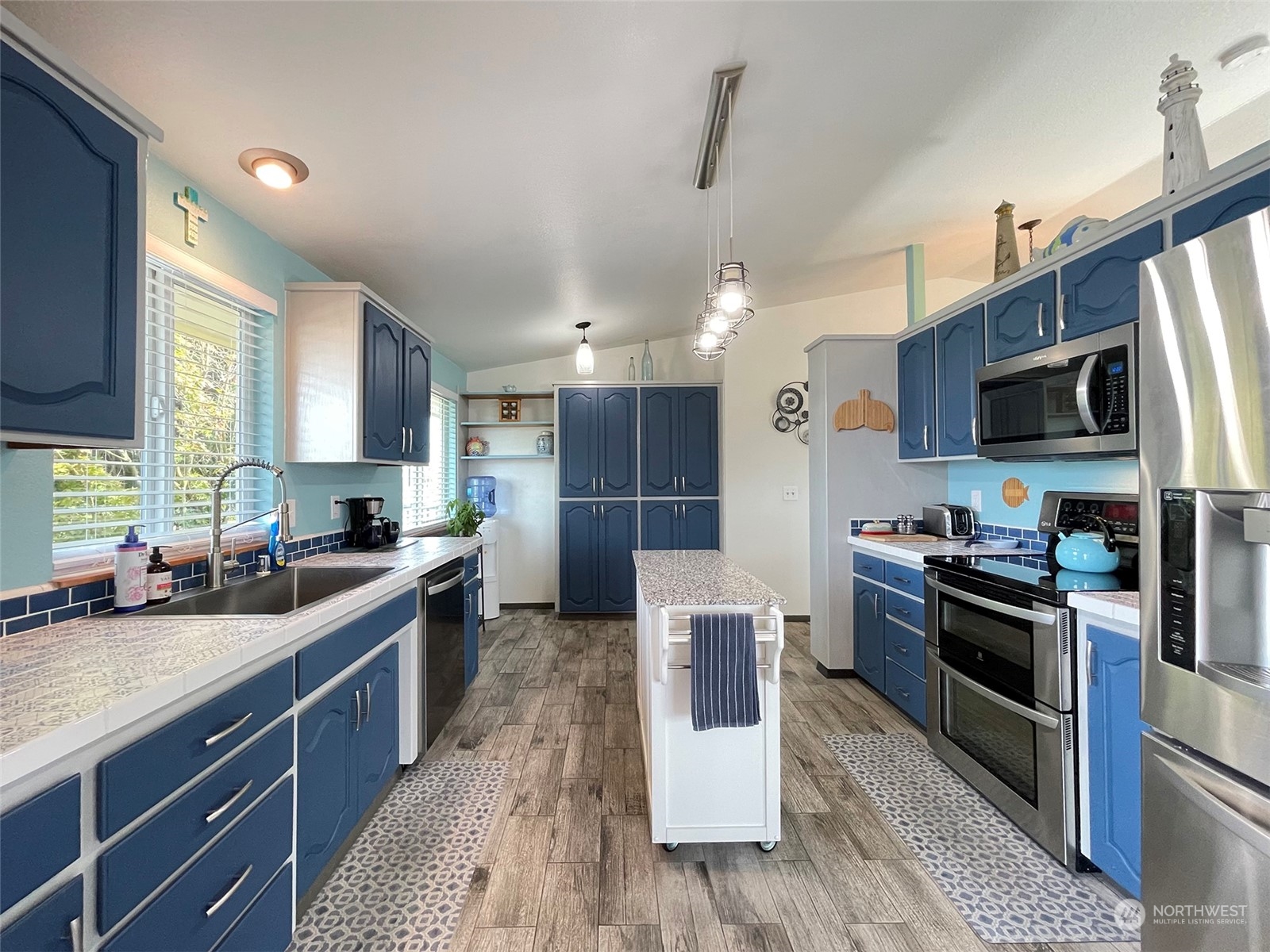190 Greywolf Road Sequim, WA 98382 - Photo 9 of 40 a large kitchen with stainless steel appliances granite countertop a stove top oven a sink dishwasher a dining table and chairs with wooden floor