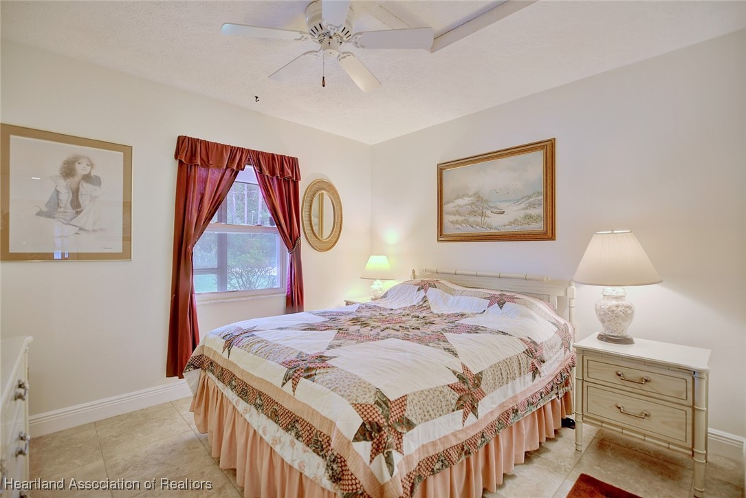 1815 Key Lake Drive Sebring, FL 33875 - Photo 18 of 41 a bedroom with a bed and a chandelier