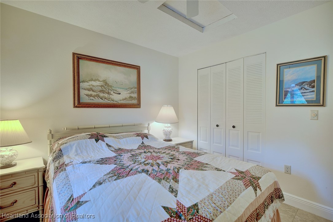 1815 Key Lake Drive Sebring, FL 33875 - Photo 19 of 41 a bedroom with a bed and a lamp on dresser