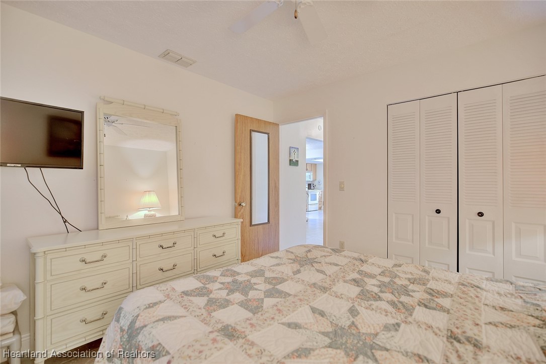 1815 Key Lake Drive Sebring, FL 33875 - Photo 25 of 41 a bedroom with a large bed and a flat tv screen on dresser