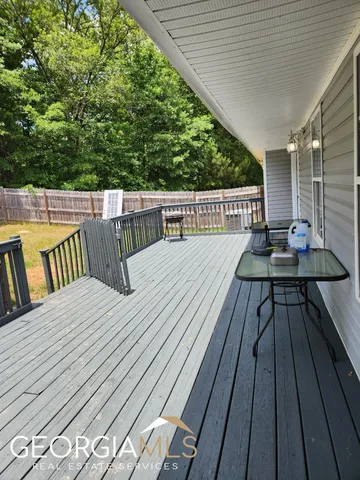 a balcony with wooden floor and outdoor seating