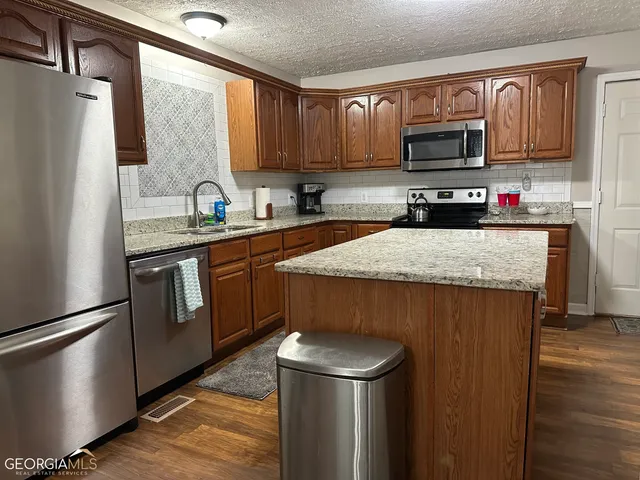 a kitchen with stainless steel appliances a microwave a sink and a refrigerator