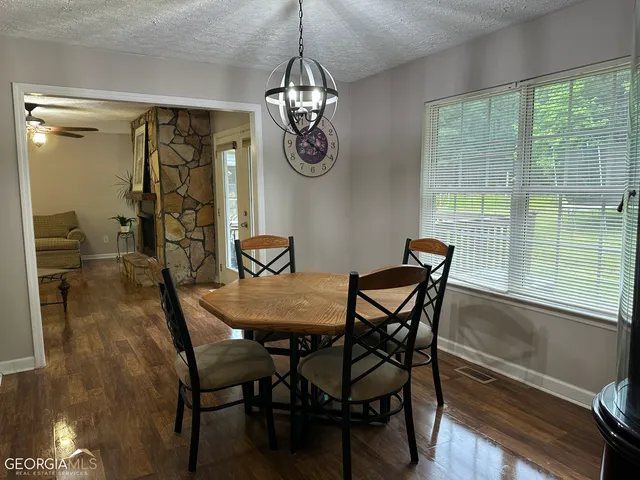 a dining room with furniture a chandelier and wooden floor