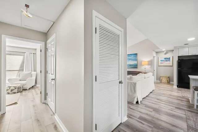 a kitchen with white cabinets and wooden floor