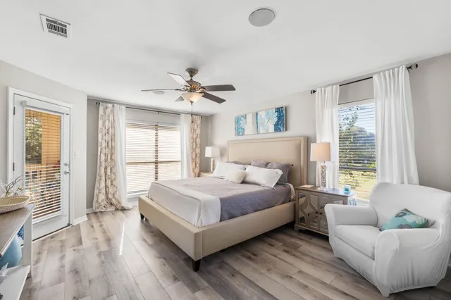 a bedroom with a large bed couch and windows