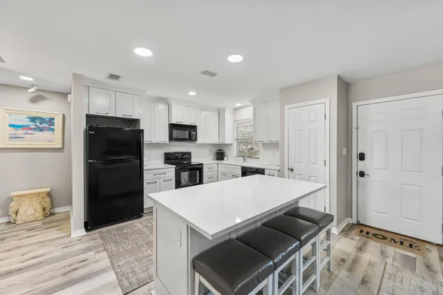 a kitchen with a refrigerator a stove top oven a sink and cabinets