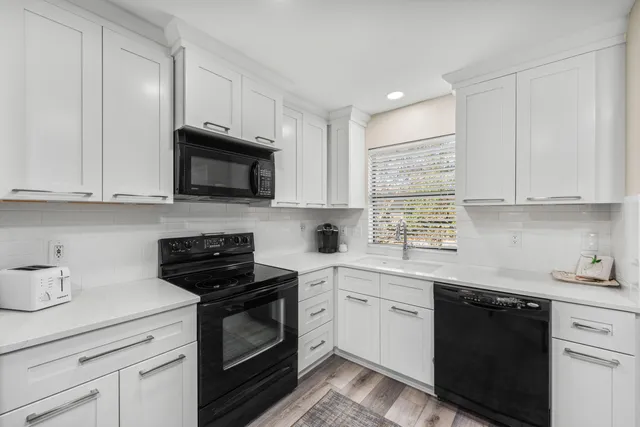 a kitchen with cabinets appliances a sink and a counter top space