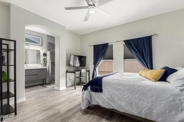 a bedroom with a bed a flat screen tv and dresser