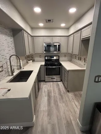 a kitchen with sink refrigerator and microwave
