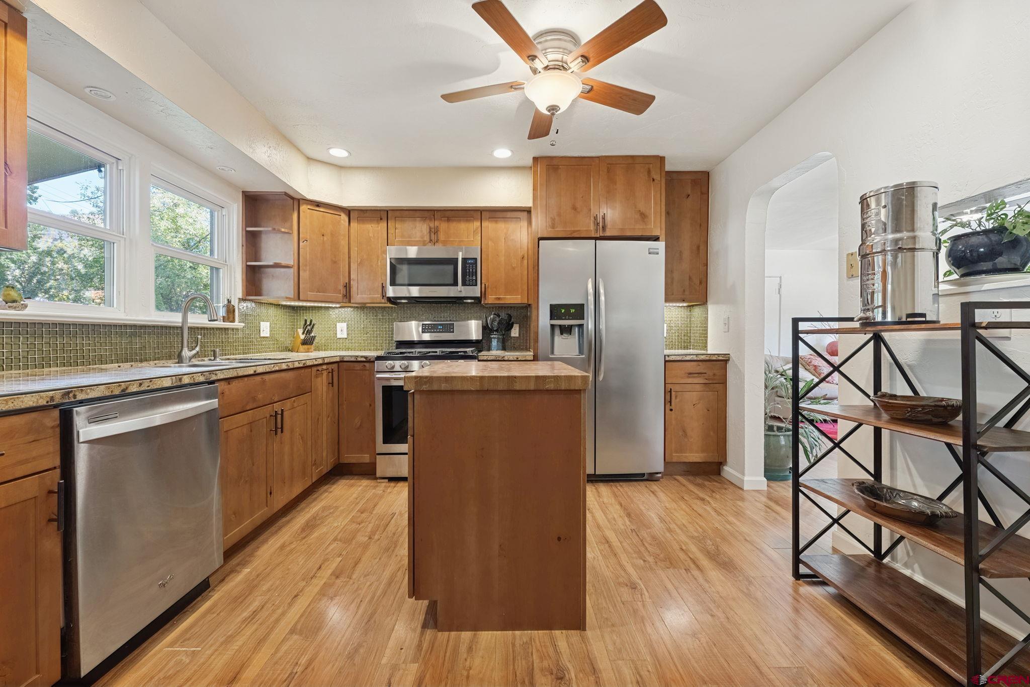 2807 Junction Street Durango, CO 81301 - Photo 4 of 26 a kitchen with stainless steel appliances a microwave a stove a sink dishwasher a refrigerator and cabinets with wooden floor