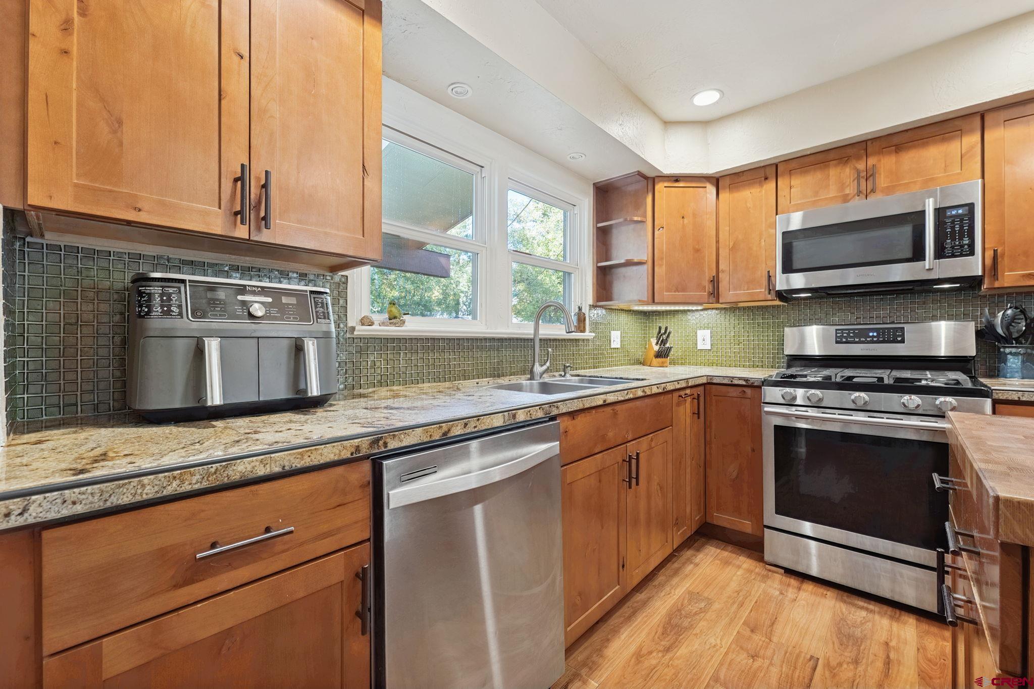 2807 Junction Street Durango, CO 81301 - Photo 5 of 26 a kitchen with stainless steel appliances granite countertop a stove a sink and a microwave