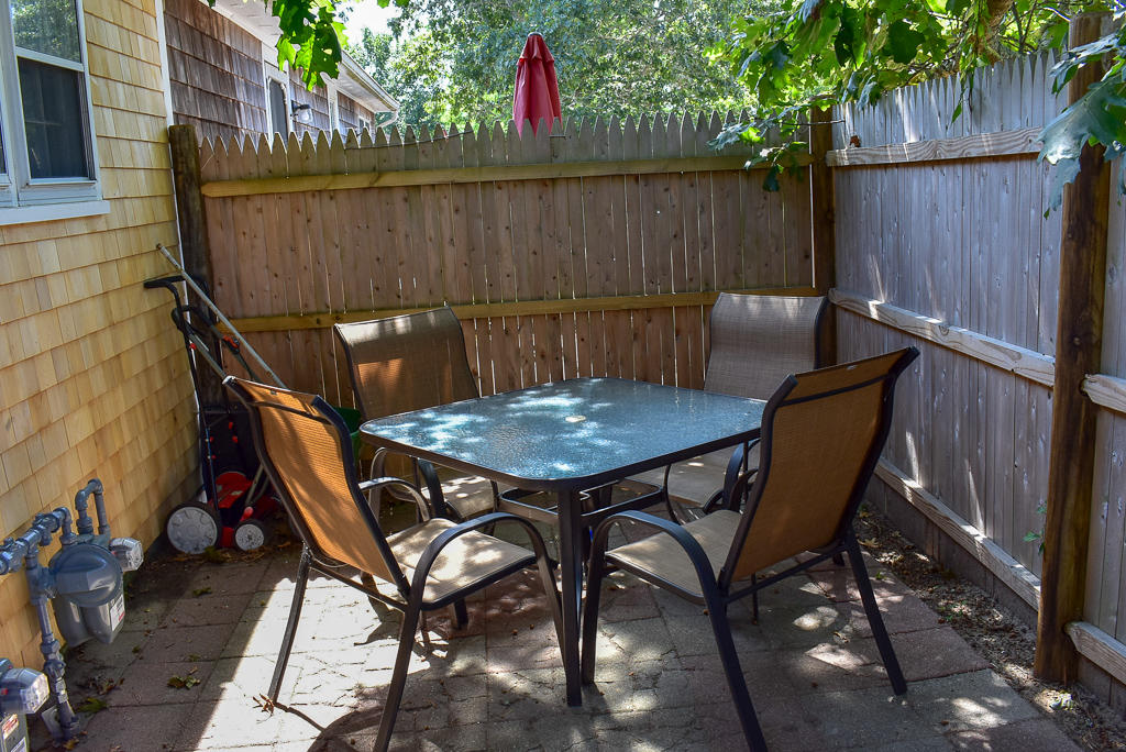 101 Lower County Road, Unit 7B Dennis Port, MA 02639 - Photo 3 of 17 a backyard of a house with table and chairs