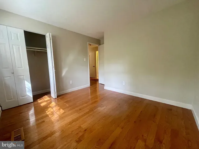 an empty room with wooden floor and closet