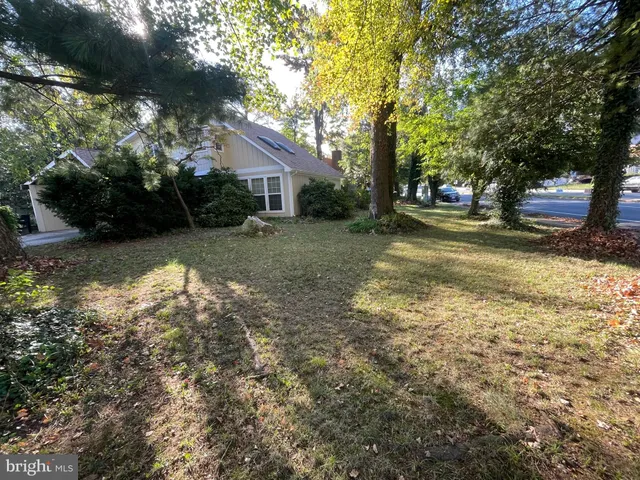 a view of a house with a yard and tree s