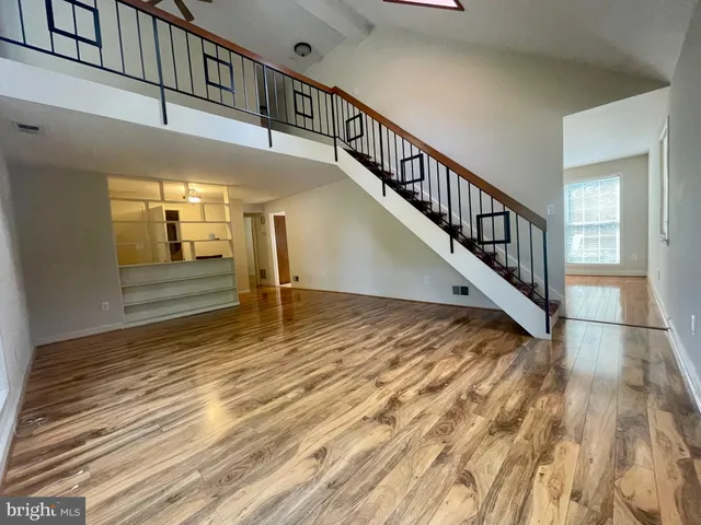 a view of a hallway with wooden floor and stairs