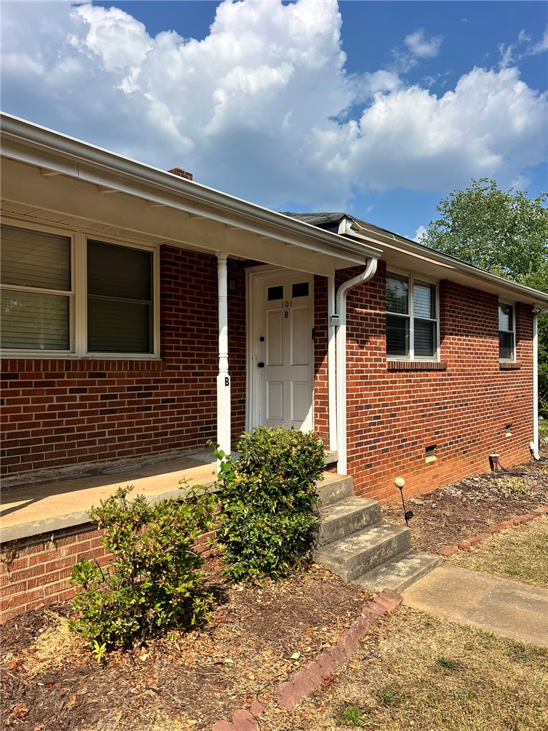 This classic brick residence presents a welcoming facade with a covered entry.