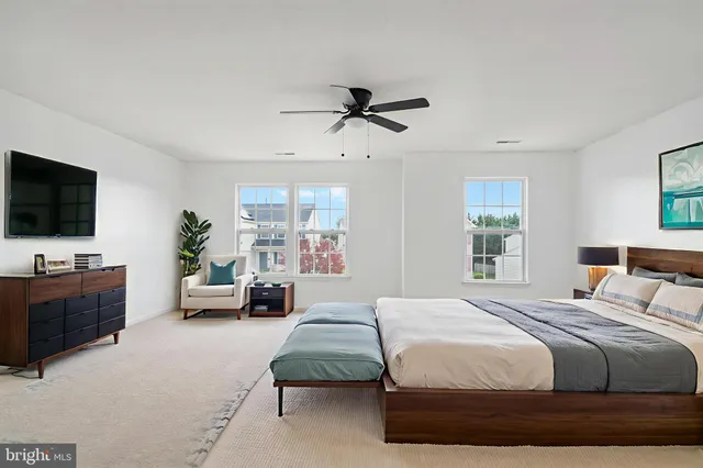 a bedroom with a bed couch tv and window