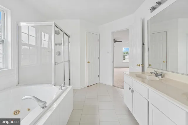 a spacious bathroom with a tub sink and mirror
