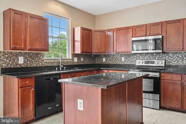 a kitchen with stainless steel appliances granite countertop a sink stove and cabinets
