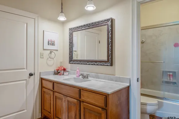 a bathroom with a sink vanity toilet and shower