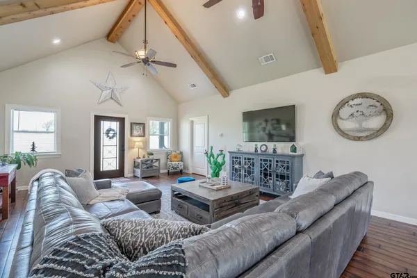 a living room with furniture a clock on wall and a window