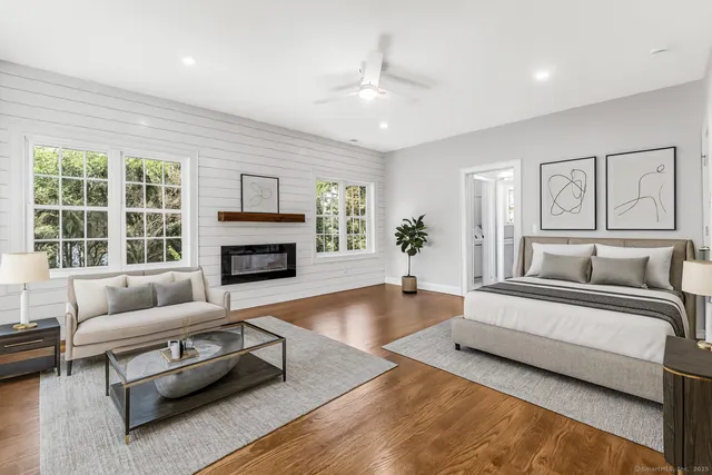 a spacious bedroom with a bed a couch and a fireplace