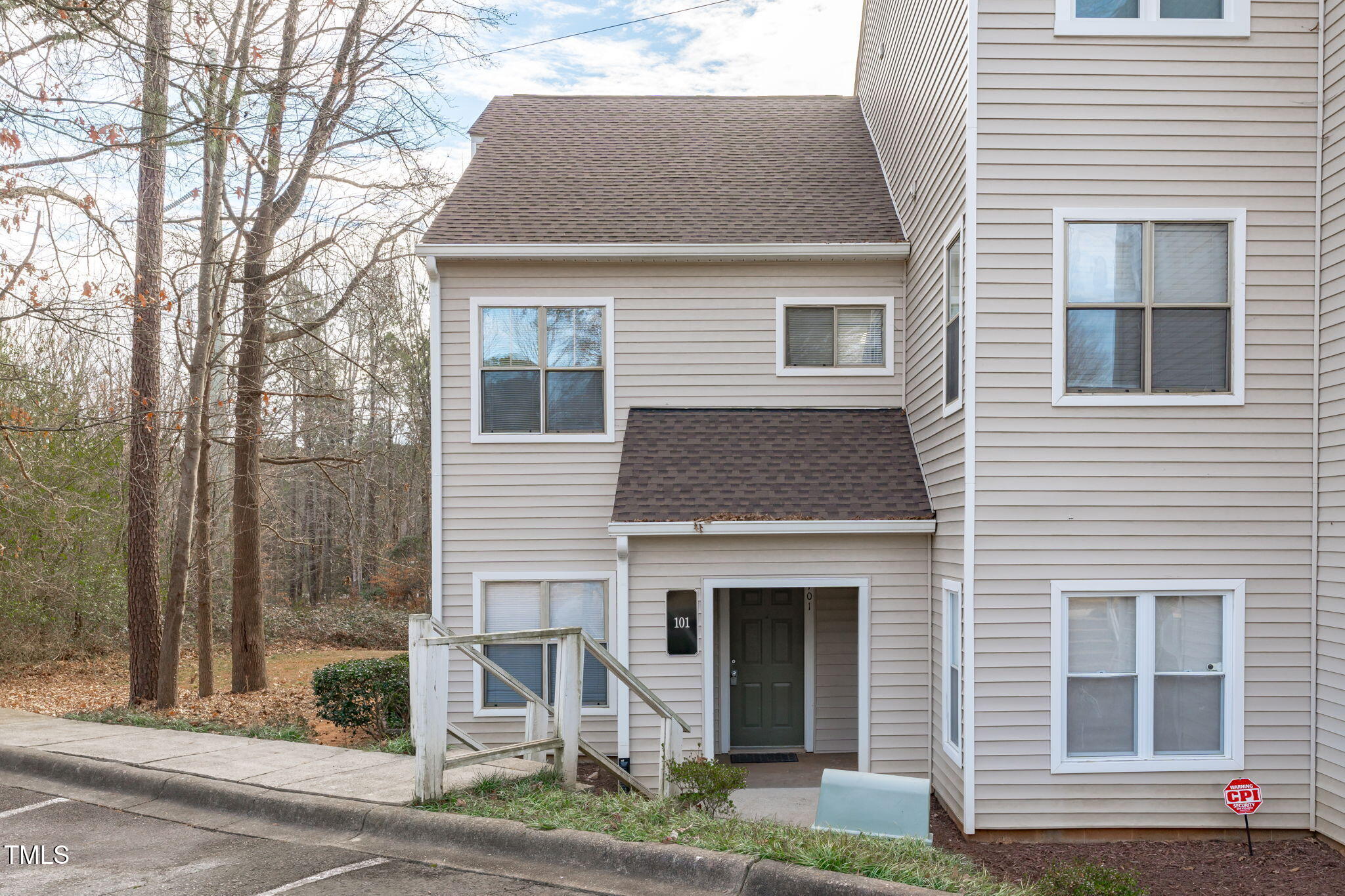 6131 Summer Pointe Place, Unit 101 Raleigh, NC 27606 - Photo 2 of 21 a front view of a house with a yard and garage