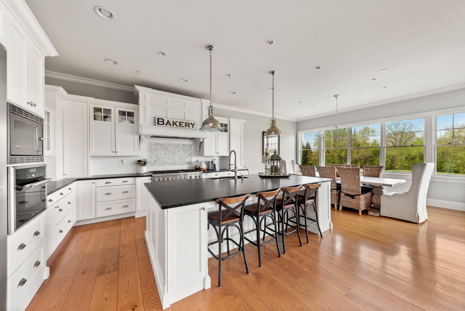 26070 West Sunset Road Barrington, IL 60010 - Photo 6 of 30 a kitchen with a table chairs stove and wooden floor