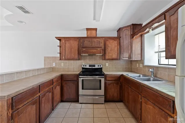 a kitchen with a sink stove top oven and cabinets