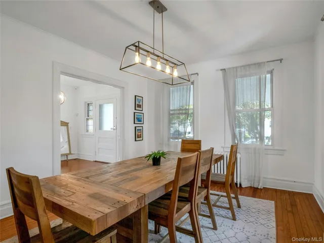 a kitchen with stainless steel appliances a sink a stove a refrigerator dining table and chairs